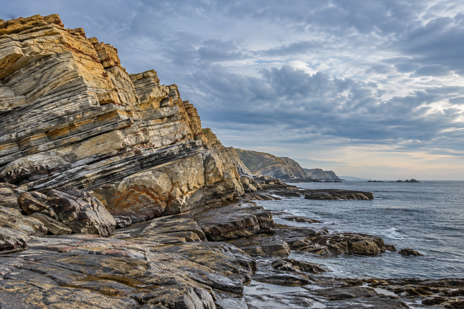 Imagined layered coastal rocks beside a quiet sea